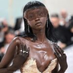 Anok Yai in elegant gown with striking accessories.