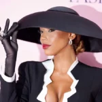 Elegant Kysre Gondrezick in dramatic black hat.